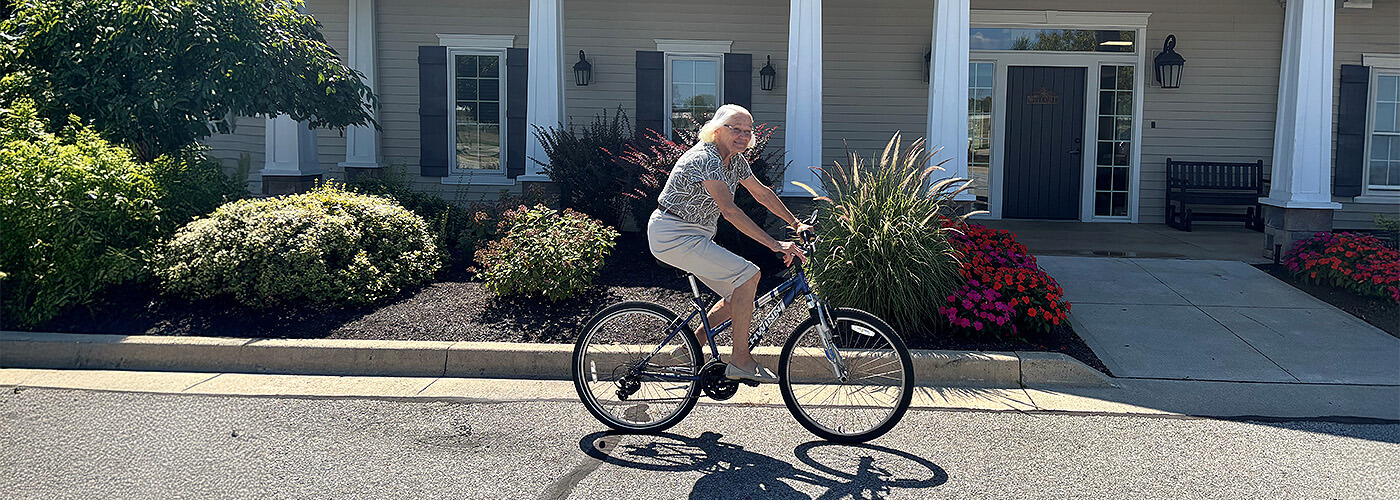 Senior resident Renate cycling through neighborhood