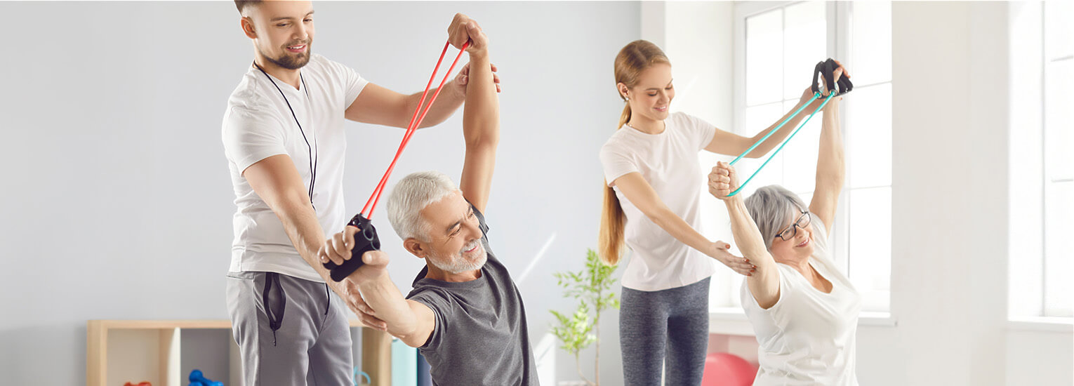 two seniors stretching with physical therapists