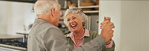 Senior couple dancing happily in their kitchen