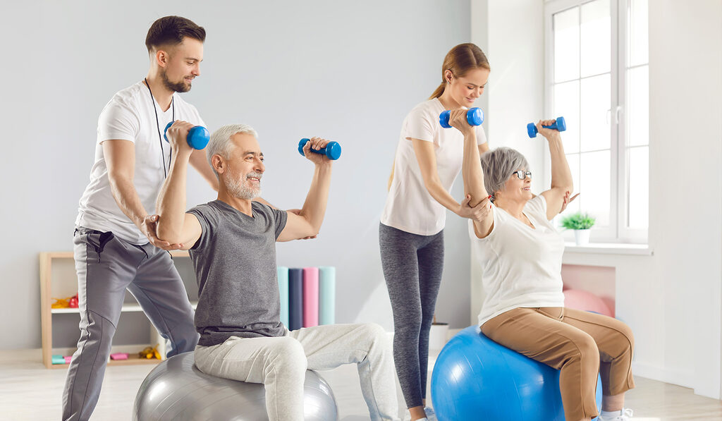 seniors in physical therapy using hand weights