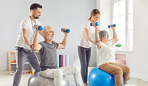 seniors in physical therapy using hand weights