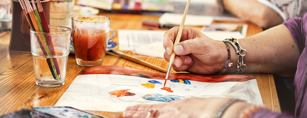 Close up of woman painting figures in an arts and crafts class