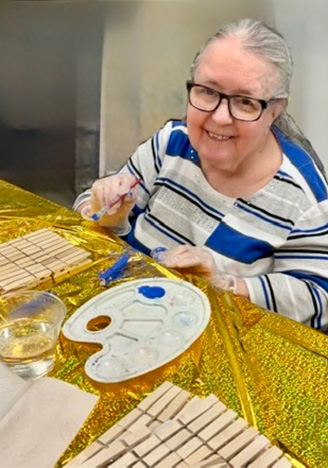 Happy senior woman smiling during arts and crafts activity