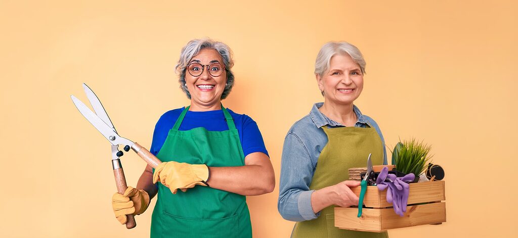 Two senior women holding up gardening supplies