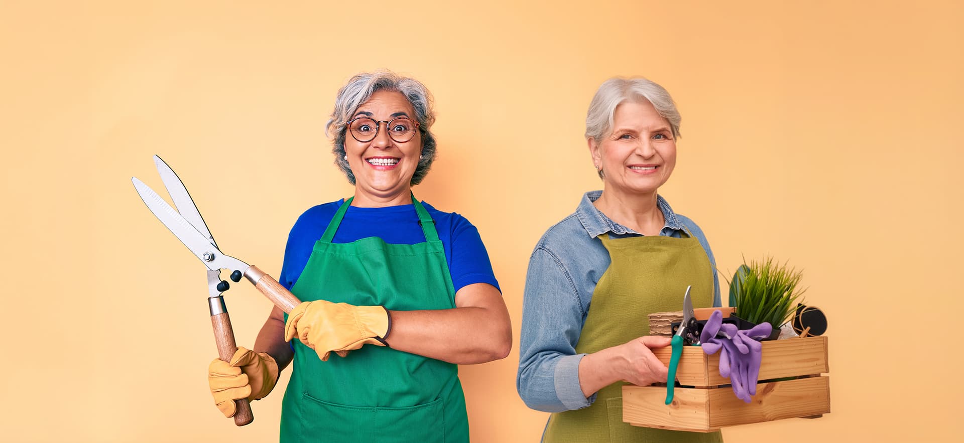 Two senior women holding up gardening supplies
