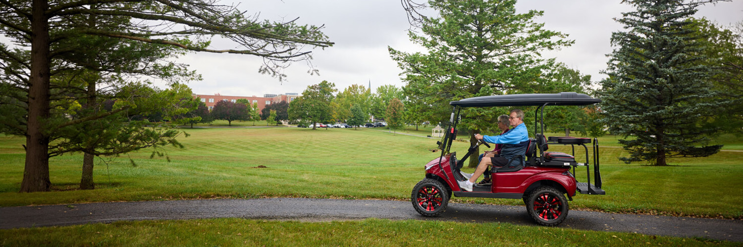 Seniors driving golf cart around Heritage Pointe Warren's Dogwood Glen Golf Course